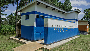 Neuer Toilettenblock für Mädchen mit blauer Fassade an einer Schule in Norduganda, gebaut im Rahmen des RISING Uganda Projekts zur Verbesserung der Hygiene und Bildungschancen.
