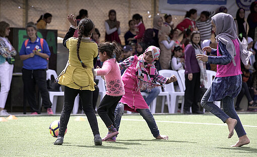 Eine Gruppe Mädchen spielt Fußball.