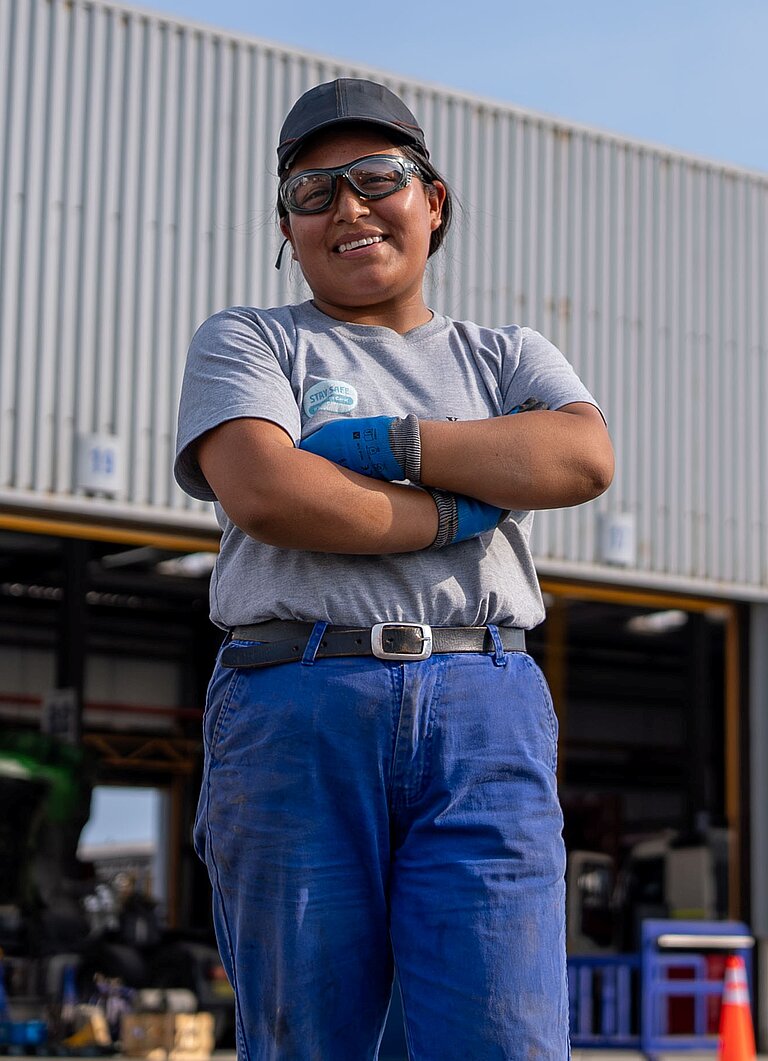 Estefany steht auf dem Parkplatz ihrer Arbeitsplatzes in Peru 