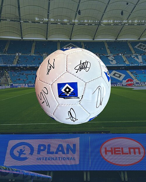 Signierter HSV-Fußball mit mehreren Unterschriften der Mannschaft liegt auf dem Spielfeld im Volksparkstadion