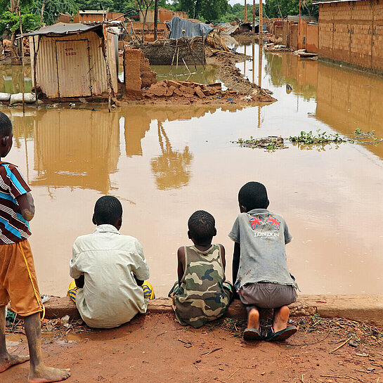 Jungs beobachten ein überschwemmtes Stadtviertel in Niamey, der Hauptstadt Nigers