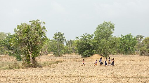 Farmland in Kambodscha Menschen durchqueren ein trockenes Feld