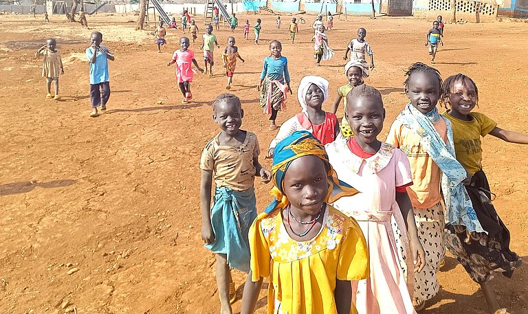 Geflüchtete Kinder in Ura, Äthiopien, die mit Freude auf die Betrachter:in zugelaufen kommen.