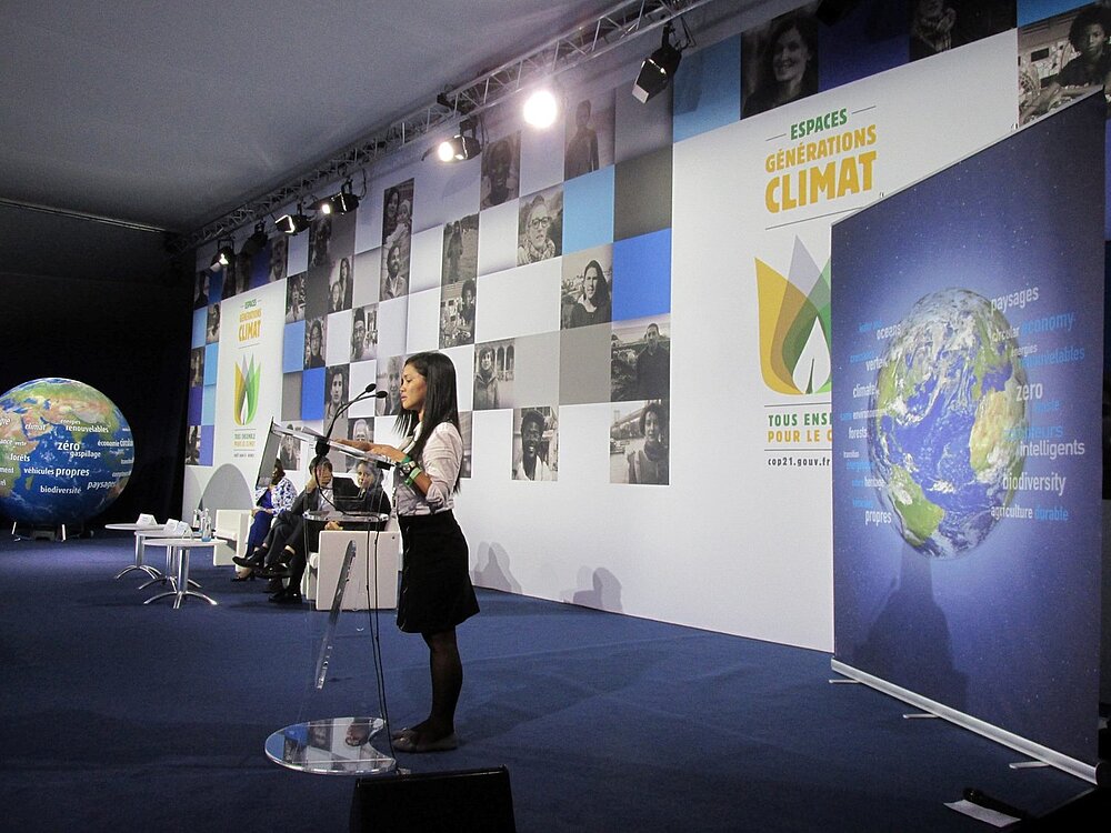 Plan-Aktivistin Marinel Ubaldo hält Rede auf der COP21-Klimakonferenz vor Publikum