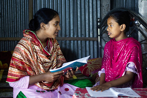 Ria spricht mit einem Mädchen aus ihrer Gemeinde in Bangladesch im Rahmen des Programms