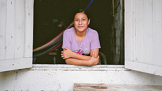 Ein junges Mädchen lehnt sich aus dem Fenster