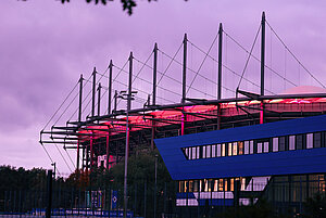 Das Volksparkstadion ist im Dunkeln anlässlich des Weltmädchentages pink beleuchtet.