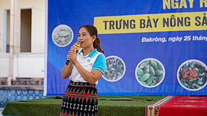 Präsentation von Frauen auf einer Agrarmesse. Junge Frau präsentiert ihre landwirtschaftlichen Fähigkeiten auf einer Bühne der Agrarmesse in Vietnam.