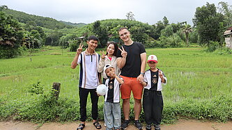 Plan Pate aus Deutschland und Familie aus Vietnam lächeln in Kamera.