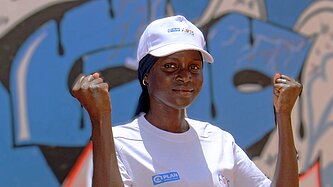 Fatou steht draußen in ihrer Gemeinde in Senegal 