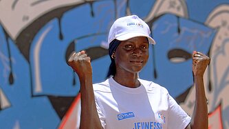 Fatou steht draußen in ihrer Gemeinde in Senegal 