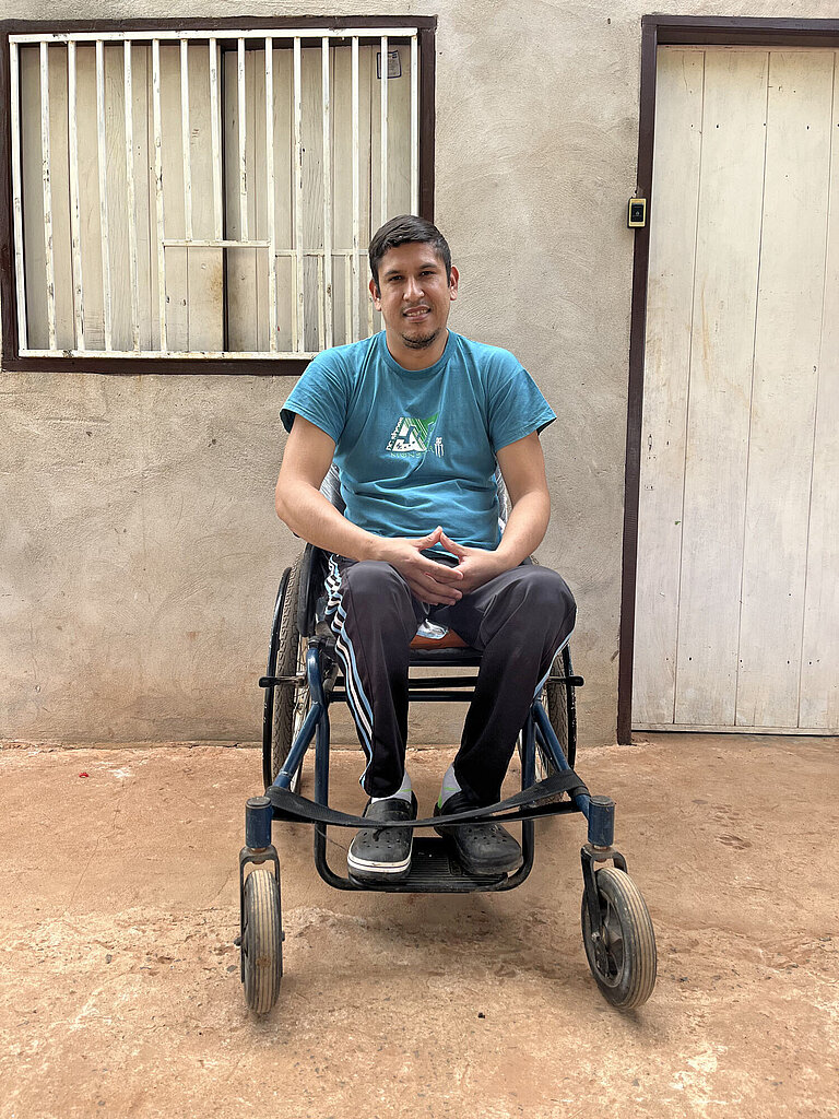 Ein junger Mann sitzt in einem Rollstuhl