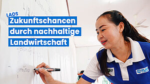 Lehrerin in Laos schreibt an Whiteboard – Text: Zukunftschancen durch nachhaltige Landwirtschaft