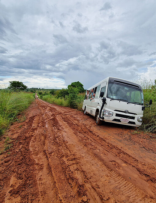 Kleinbus fährt über eine unbefestigte Straße in ländlichem Malawi.