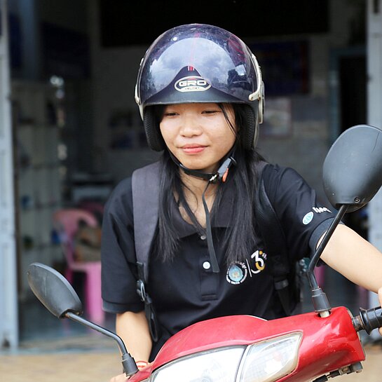 Eine Nahaufnahme von Kann auf ihrem roten Moped
