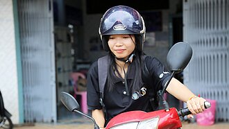 Eine Nahaufnahme von Kann auf ihrem roten Moped