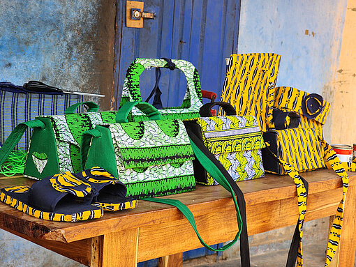 Selbstgemachte bunte Taschen und Slipper auf einem Holztisch