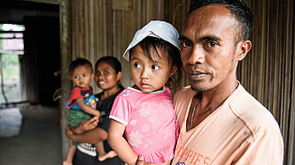 Ein Mann trägt sein Kind auf dem Arm