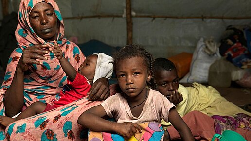 Eine Mutter und ihre Kinder leben in einer von Plan gebauten Unterkunft.