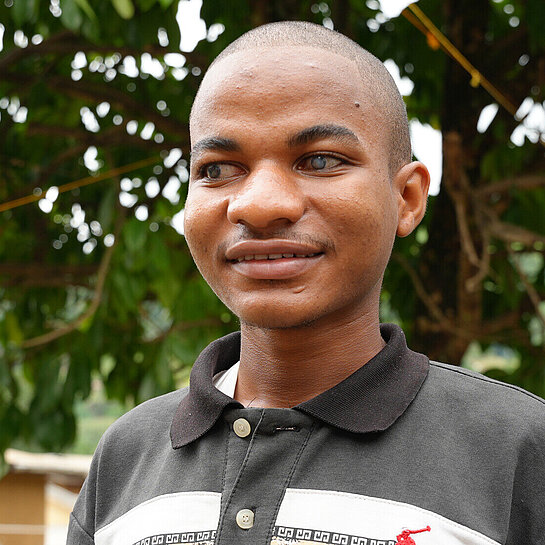 Ein blinder junger Mann im Porträt, er lächelt