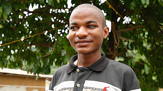 Ein blinder junger Mann im Porträt, er lächelt