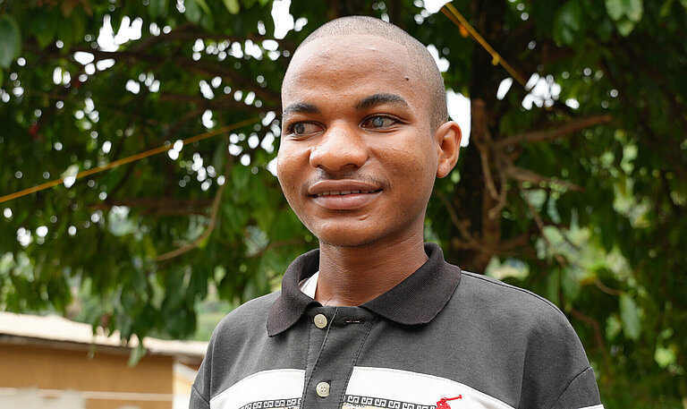 Ein blinder junger Mann im Porträt, er lächelt