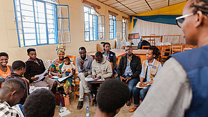 Teilnehmende eines landwirtschaftlichen Trainingsprojekts in Ruanda diskutieren in einer Gruppensitzung.