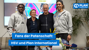 Mitarbeitende von Plan International stehen mit zwei Profi-Spielern vom HSV im Büro von Plan. Auf einer Textkachel steht: "Fans der Patenschaft: Der HSV und Plan International".
