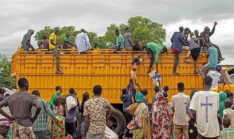 Ein Kind wird vom Lastwagen gereicht