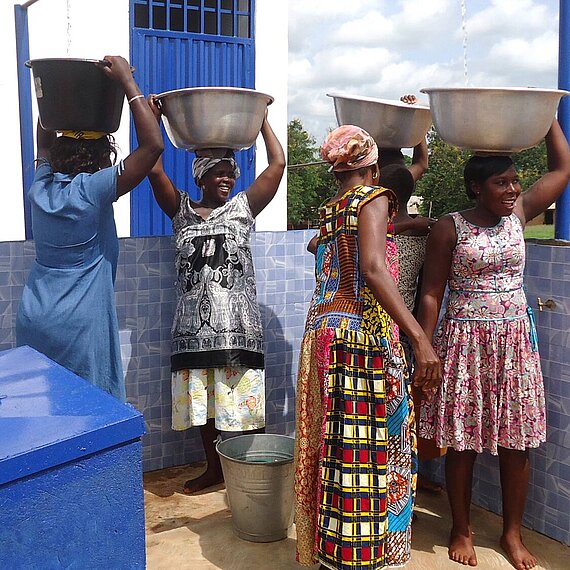 Frauen in Ghana holen Wasser an einer Wasserstelle Frauen in Ghana holen Wasser an einer Wasserstelle
