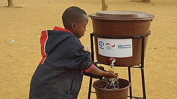 Ein malischer Junge bei der Nutzung der von Plan bereitgestellten Handwasch-Einrichtungen. © Plan