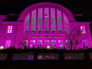 Das Holthusenbad ist im Dunkeln anlässlich des Weltmädchentages pink beleuchtet.
