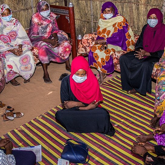 Gruppendiskussion zwischen Frauen mit Gesichtsmasken