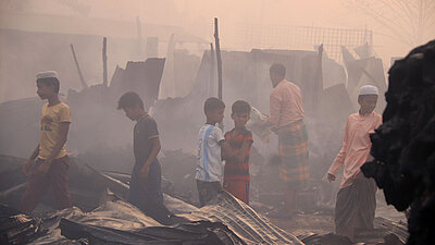 Kinder bahnen sich ihren Weg durch die Ruinen ihrer Häuser im Flüchtlingslager