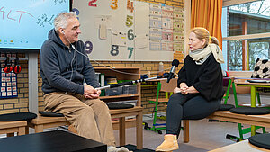 Journalist Thomas Samboll interviewt Klassenlehrerin Janine Neumann für den Deutschlandfunk.