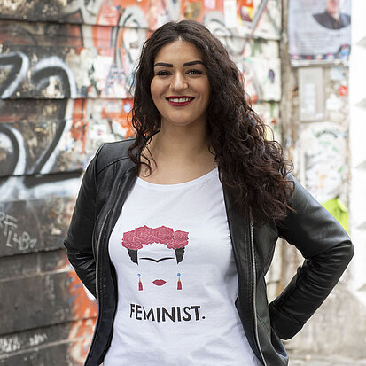 Eine Frau mit einem T-Shirt, auf dem Feminist steht