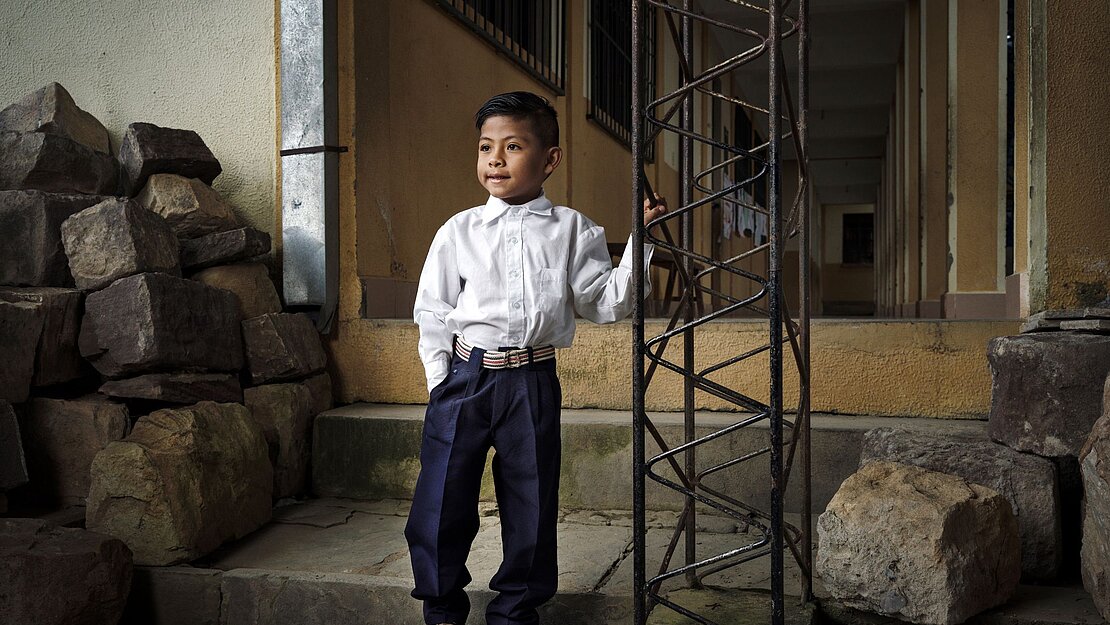 Junge in Schule in Bolivien stehend 