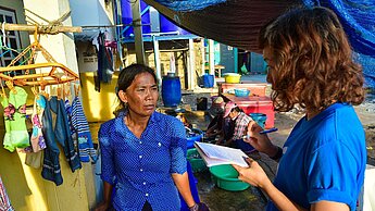 Eine Plan-Mitarbeiterin interviewt Pa, die vor 15 Jahren mit ihrem Mann nach Thailand kam. © Pattapong Polek/Plan