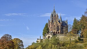 Historisches Schloss auf einem Hügel Historisches Schloss auf einem bewaldeten Hügel an einem sonnigen Tag.
