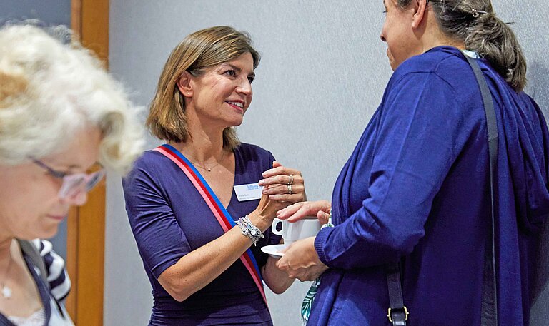 Frau Julia Selle steht als Geschäftsführerin der Stiftung Hilfe mit Plan Deutschland mit einer Stifterin beratend zusammen