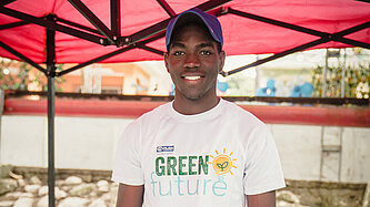 Ein junger Mann steht hinter einem Marktstand mit Schmuckgegenständen