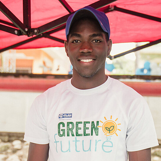 Ein junger Mann steht hinter einem Marktstand mit Schmuckgegenständen