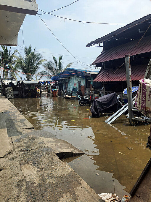 Überflutete Straße mit Palmen im Hintergrund