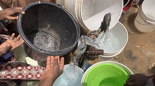 Menschen in Nigeria sammeln Flusswasser in Eimern Menschen sammeln Flusswasser in Plastikeimern