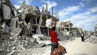 Ein Zurückgekehrter trägt sein Hab und Gut durch Rafah 