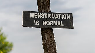 Schild mit Aufschrift „Menstruation is normal“