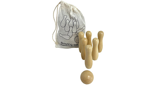 Sechs Holzkegel und eine Kugel vor dem Baumwollbeutel.