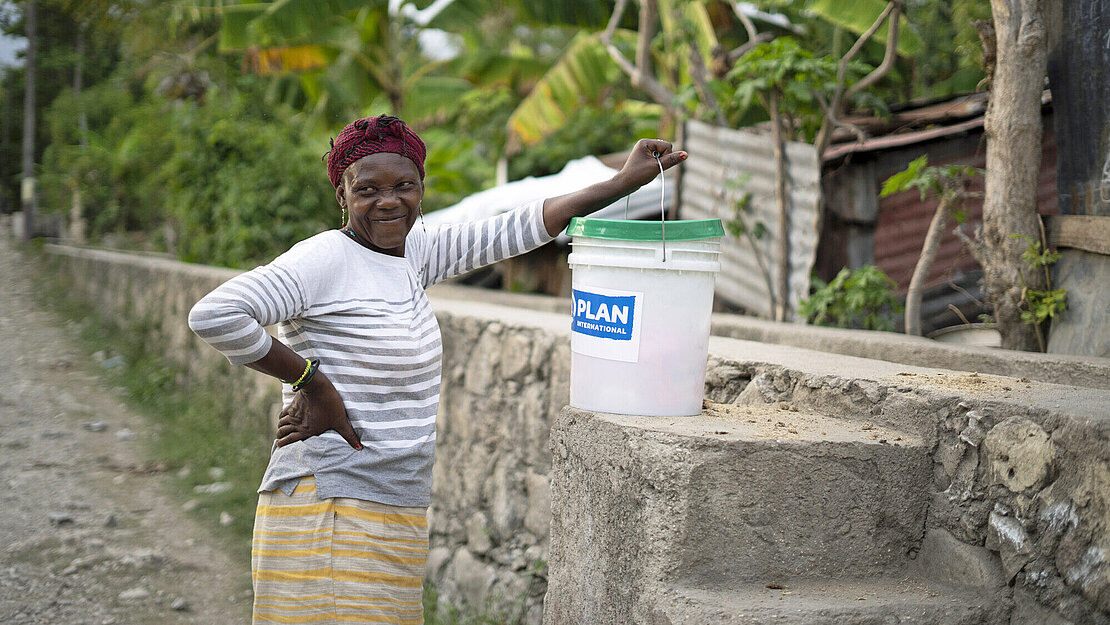 Eine Frau freut sich über ein Hygieneset von Plan International