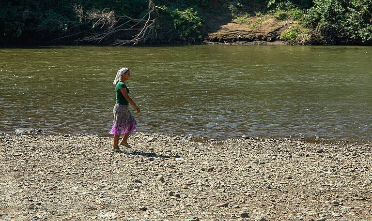 Eine Frau steht am Ufer des Río Lempa