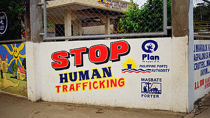 Auf einer Wand steht groß "STOP Human Trafficking" geschrieben